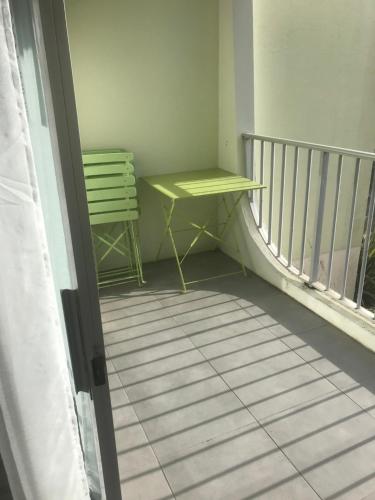 d'un balcon avec une table jaune et une chaise verte. dans l'établissement Locations Saint Palais, à Saint-Palais-sur-Mer