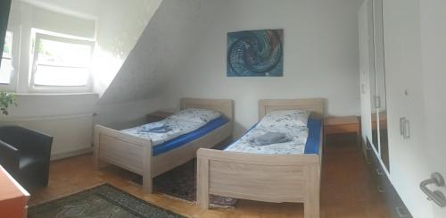 a small room with two beds and a window at Ferienwohnung Weserbergland in Hessisch Oldendorf