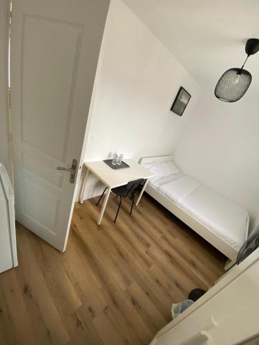 a small room with a white couch and a table at G-Logement-Francilien Aéroport CDG, Parc des expositions Villepinte, Bourget, Astérix. in Goussainville