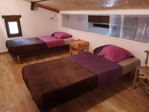 - 2 lits dans une chambre avec des draps violets dans l'établissement Gîte équestre en Provence aux pieds des Alpilles, à Maillane