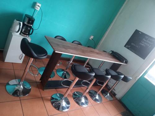 a table and stools in a room at Valparadise Hostel in Valparaíso