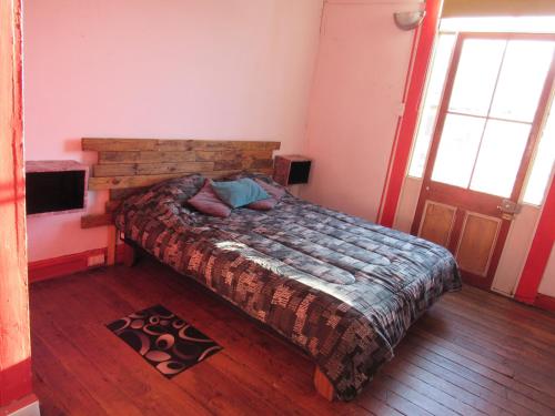 a bedroom with a bed and a wooden floor at Valparadise Hostel in Valparaíso