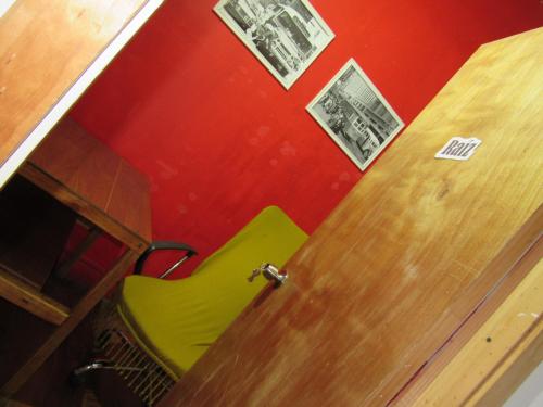 a green chair in a room with a door at Valparadise Hostel in Valparaíso