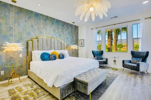 a bedroom with a large bed and two chairs at Lakeside Luxury in Indio