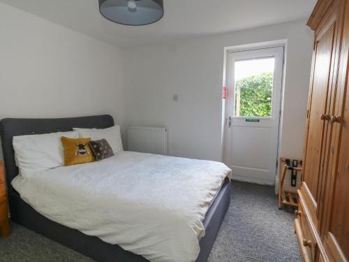 a bedroom with a bed with white sheets and a window at Flat 1 - Sandbanks in Bournemouth