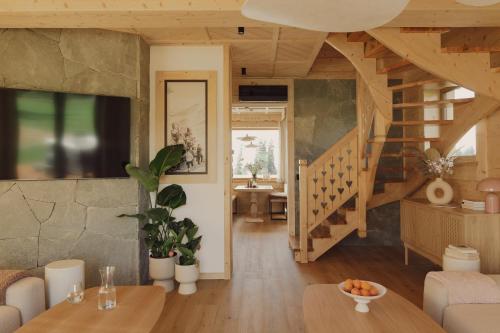 a living room with a staircase and a table at Lovelia Luxury Chalet in Zakopane