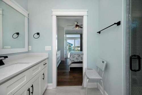 a white bathroom with a sink and a mirror at Sea-Batical in Oak Island