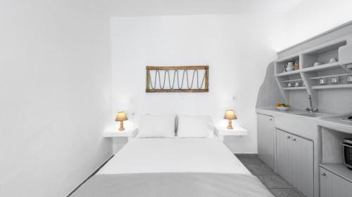 a white room with two beds and a sink at Anerousses in Adamantas