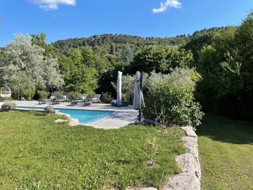 - une piscine avec un parasol, des chaises et des arbres dans l'établissement Dépendance en Provence, à Simiane-Collongue