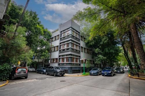 a tall white building with cars parked in front of it at La Campechana in the heart of Roma and Condesa in Mexico City