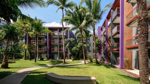 a park with palm trees in front of a building at Holiday Inn Express Phuket Patong Beach Central by IHG in Patong Beach