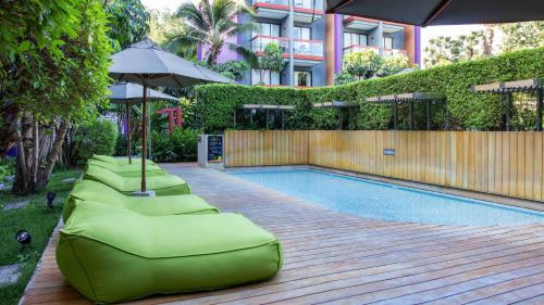 a row of chaise lounges next to a swimming pool at Holiday Inn Express Phuket Patong Beach Central by IHG in Patong Beach