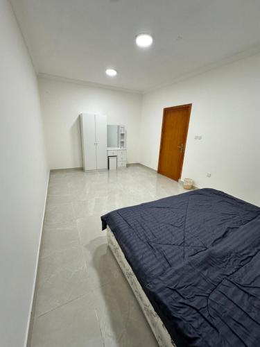 a bedroom with a bed in a white room at نجوم السعد 9 in Al Masfalah