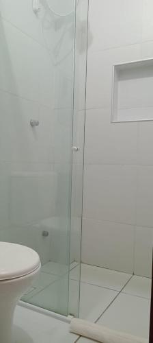a glass shower in a bathroom with a toilet at Pousada Morada do Sol in Camocim