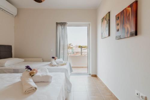two beds in a white room with a window at Elia House Nafplio in Nafplio