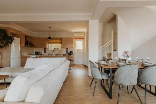 a living room with a white couch and a table and chairs at Elia House Nafplio in Nafplio