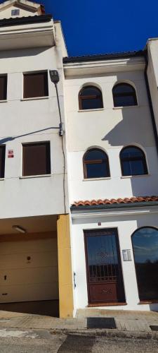 a white building with a garage next to it at El ático de María in Ruidera