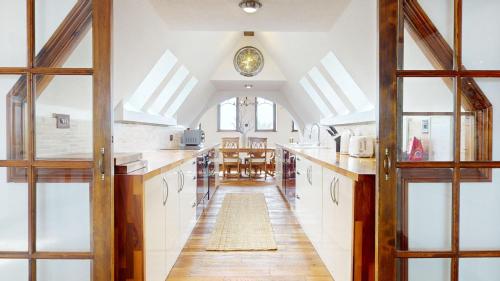 an attic kitchen with white cabinets and a dining room at Spacious 4-Bedroom Penthouse Sleeps 8 - Great City View and Free Parking in Portsmouth