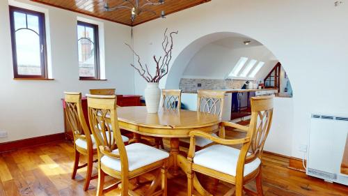 a dining room with a wooden table and chairs at Spacious 4-Bedroom Penthouse Sleeps 8 - Great City View and Free Parking in Portsmouth