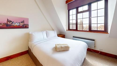 a bedroom with a large white bed and a window at Spacious 4-Bedroom Penthouse Sleeps 8 - Great City View and Free Parking in Portsmouth