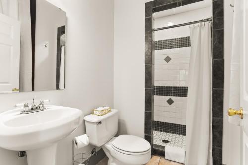 a bathroom with a toilet and a sink and a shower at Site 61 Guesthouse in New Orleans