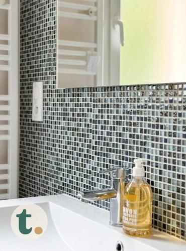 - un lavabo avec une bouteille de savon et un miroir dans l'établissement Tranquiloue - Maison moderne - Proche PuyduFou, à Mesnard-la-Barotière