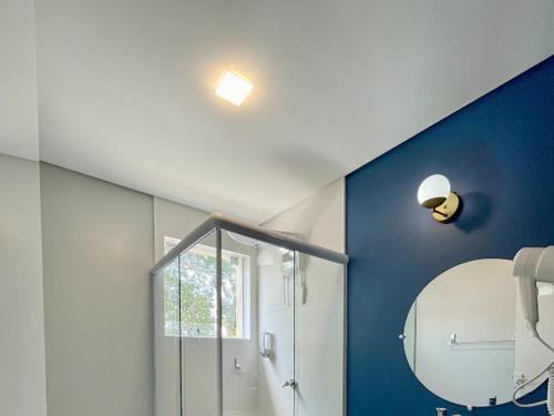 a bathroom with a shower and a mirror at Costa Solar Lagoa in Florianópolis