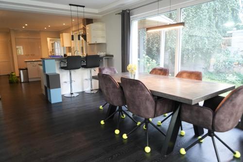 a dining room with a wooden table and chairs at Berlin Bound Retreat 3 bedrooms in Teltow