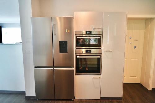 a stainless steel refrigerator and oven in a kitchen at Berlin Bound Retreat 3 bedrooms in Teltow
