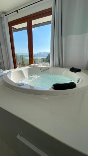 a bathroom with a bath tub with a window at Villa Mavi - Praia do Rosa in Imbituba
