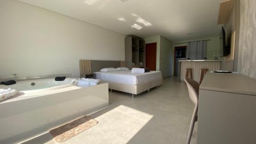 a large bathroom with a bed and a bath tub at Villa Mavi - Praia do Rosa in Imbituba