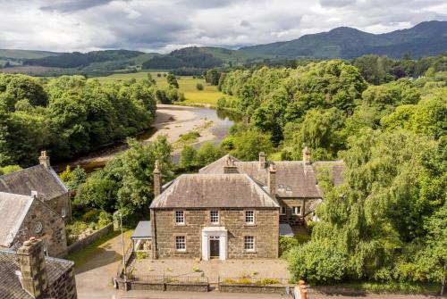 an aerial view of an old stone house with a river at Comrie Old Schoolhouse in Comrie