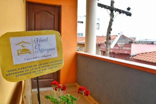 a sign in front of a window with a cross at Hotel el Marqués in Vallegrande