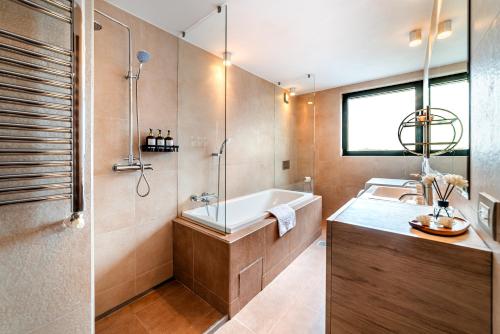 a bathroom with a tub and a sink at Starshine Spectrum Residence in Constanţa
