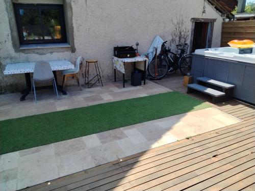 a patio with a patch of grass and a table at L'Orangerie in Idron