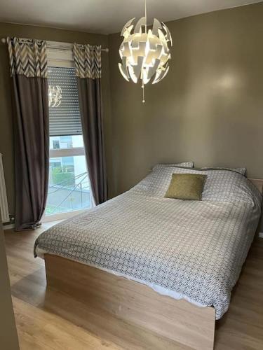 une chambre avec un lit et un lustre dans l'établissement Grand appt proche Paris Parking, à Aubervilliers
