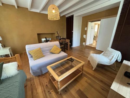 a living room with a couch and a coffee table at Domaine Manilea - Piscine - Proche Océan in Saint-Laurent-de-la-Prée