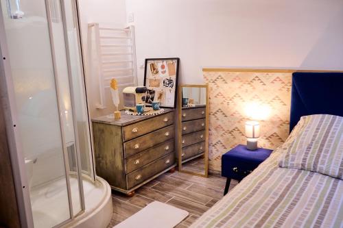 La salle de bains est pourvue d'une douche, d'un lit et d'une commode. dans l'établissement Isaiah House cosy Garden, à Deuil-la-Barre