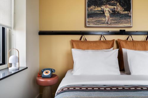 a bedroom with a bed and a clock on a table at Moxy Springfield Downtown in Springfield