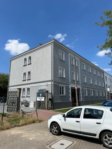 a white car parked in front of a building at Sleep&Fly Okęcie Warsaw Airport in Warsaw