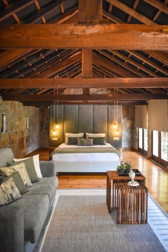 a bedroom with a bed and a couch in a room at QUINTA DO RIBEIRO Garden House in Lousada