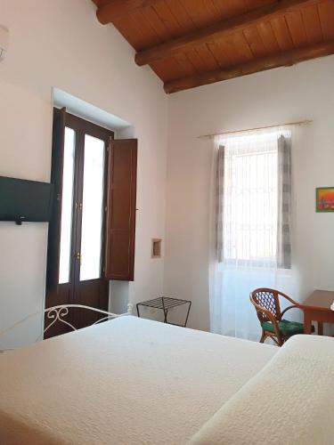 a bedroom with a bed and a table and a window at Morfeo Charming Rooms & Relax in Avola