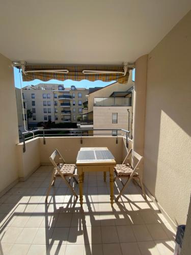 une table et deux chaises sur un balcon dans l'établissement Modern Apartment in Cannes, à Cannes
