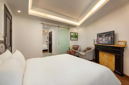 a bedroom with a white bed and a fireplace at Sapa Praha Hotel in Sa Pa
