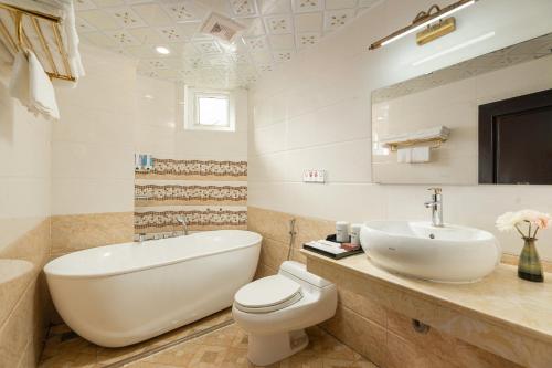 a bathroom with a toilet and a sink and a tub at Sapa Praha Hotel in Sa Pa