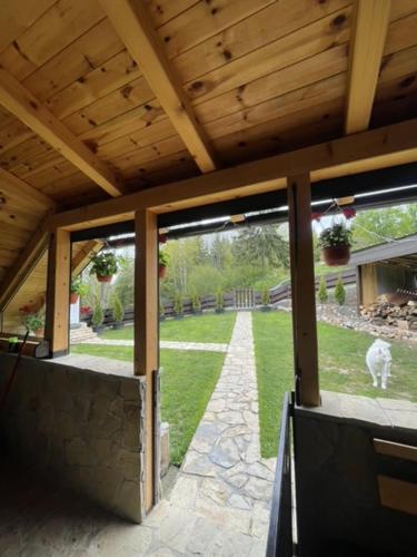 a pavilion with a dog walking in the yard at Planinska kuca ANDJELA 1 in Mitrovac