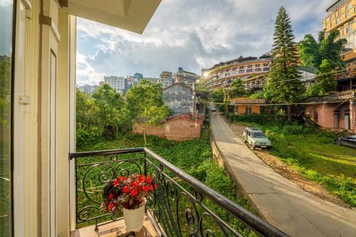 a balcony with a vase of flowers on a street at Sapa Praha Hotel in Sa Pa