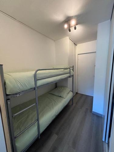 une chambre avec deux lits superposés et un placard dans l'établissement STUDIO 4 PERS SUD - L'Etoile des Rennes - Superdevoluy PIED DES PISTES, à Saint-Étienne-en-Dévoluy