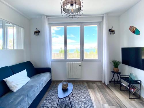 un salon avec un canapé bleu et une télévision dans l'établissement LESPARISNORMANDS - le Pokerdas 1, à Villers-sur-Mer
