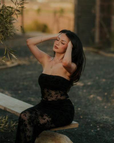 a woman in a black dress sitting on a rock at Bajo Estrellas Hotel Contemporáneo in Valle de Guadalupe